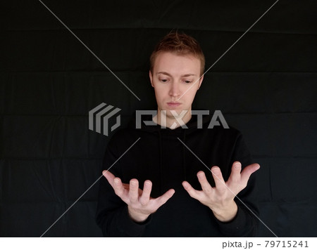 手のひらを見ている男 外国人男性 黒バック 手のひらを見ている男 外国人男性 黒バック 79715241