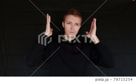 私には理解できないとジェスチャーで表している男　外国人男性　黒バック 79715254