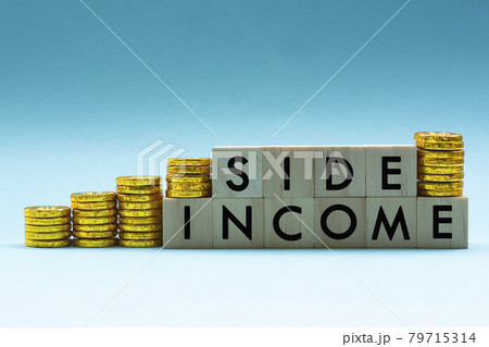Side income text on wood block with a pile of coins on a blue and white background Side income text on wood block with a pile of coins on a blue and white background 79715314