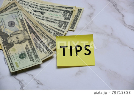 Text on yellow sticker note with US dollar bills 79715358