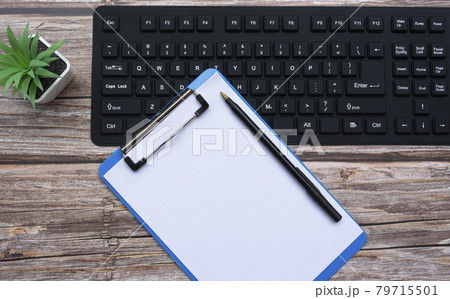 Home office workspace with keyboard, clipboard, pen and potted plant. Flat lay, top view 79715501