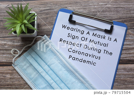 Text on blue clip board with potted plant and face mask on wooden desk Text on blue clip board with potted plant and face mask on wooden desk 79715504