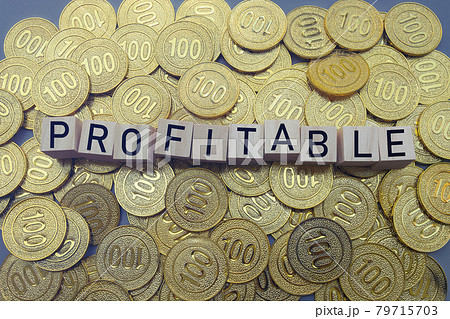 Profitable text on wood block with a pile of coins 79715703