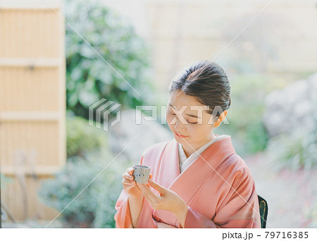 お猪口で日本酒を飲む着物姿の20代女性 79716385