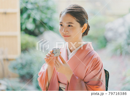 お猪口で日本酒を飲む着物姿の20代女性 79716386