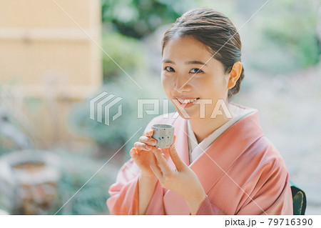 お猪口で日本酒を飲む着物姿の20代女性 79716390