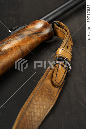 Wooden handle of hunting rifle on dark wooden background Wooden handle of hunting rifle on dark wooden background 79717685