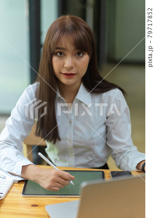 Gorgeous businesswoman working at office with tablet Gorgeous businesswoman working at office with tablet 79717852