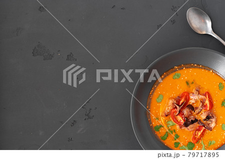 Tom yam Thai soup in black bowl served on gray background 79717895