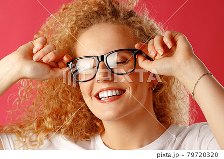 Joyful young curly woman in glasses smiling Joyful young curly woman in glasses smiling 79720320