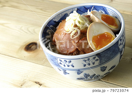 キャベツの千切りに味玉、ネギがトッピングされた焼豚丼 キャベツの千切りに味玉、ネギがトッピングされた焼豚丼 79723074