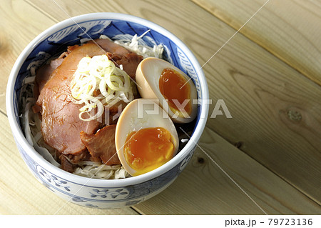 キャベツの千切りに味玉、ネギがトッピングされた焼豚丼を俯瞰で撮影 79723136