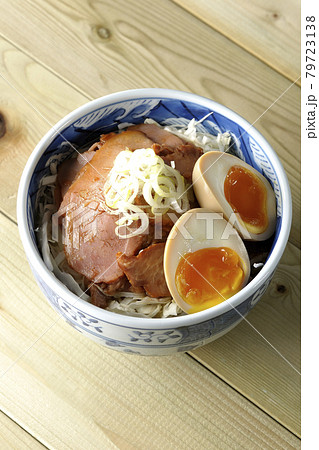 キャベツの千切りに味玉、ネギがトッピングされた焼豚丼を俯瞰で撮影 79723138