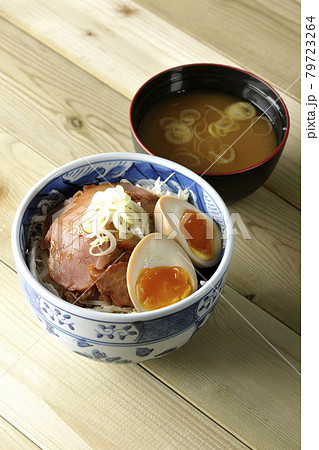キャベツの千切りに味玉、ネギがトッピングされた焼豚丼と味噌汁のセット キャベツの千切りに味玉、ネギがトッピングされた焼豚丼と味噌汁のセット 79723264