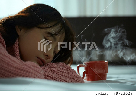 ベッドの上でリラックスする若い女性 ベッドの上でリラックスする若い女性 79723625