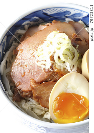キャベツの千切りに味玉、ネギがトッピングされた焼豚丼を白背景で俯瞰撮影 79723811