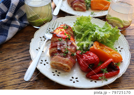 Dinner background. Grilled chicken breast wrapped in bacon served with salad on wooden rustic table . Top view . Dinner background. Grilled chicken breast wrapped in bacon served with salad on wooden rustic table . Top view . 79725170