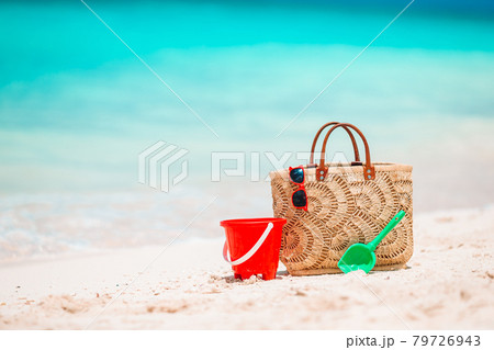 Beach accessories - straw bag, hat and unglasses on the beach 79726943