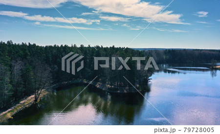 Aerial view of a Lake in the heath in northern Germany , with dense forest along the banks, blue water and small ripples Aerial view of a Lake in the heath in northern Germany , with dense forest along the banks, blue water and small ripples 79728005