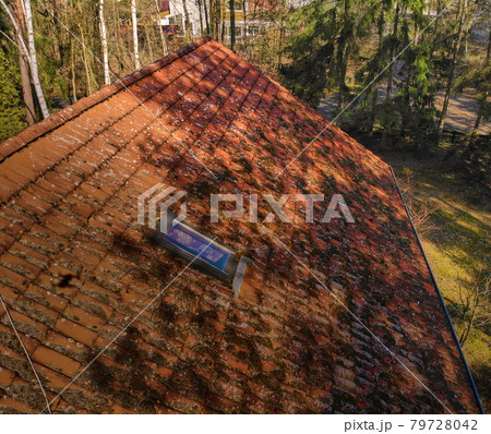 Inspection of the red tiles of the roof of a family house with a drone, aerial photo 79728042