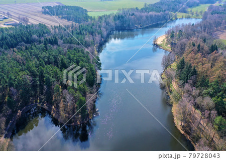 Aerial view of a Lake in the heath in northern Germany for recreational use, with dense forest along the banks 79728043