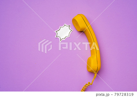 Yellow landline phone with speech bubble on purple background Yellow landline phone with speech bubble on purple background 79728319