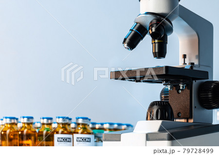 Medical vial with medication near microscope photo 79728499