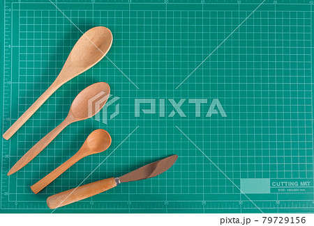 Kitchenware and wood spoon on cutting mat background. Kitchenware and wood spoon on cutting mat background. 79729156