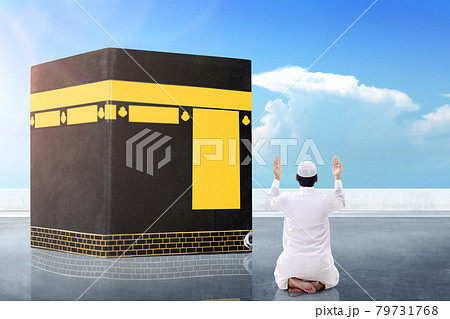 Rear view of Asian Muslim man sitting and praying in front of the Kaaba Rear view of Asian Muslim man sitting and praying in front of the Kaaba 79731768