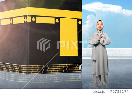 Asian Muslim little girl in a veil standing with greetings gesture 79732174
