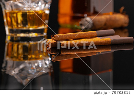 Glass of whisky and cigar on black background 79732815