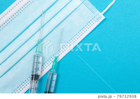 Syringe with Medical Mask on Blue Table - Flat Lay 79732938