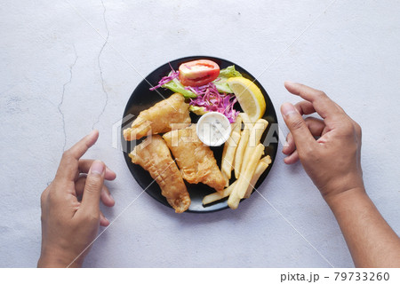 Fish fillet, lemon , chips and potato mash on table  79733260