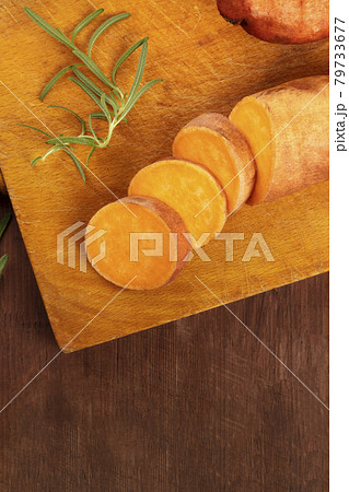 Slices of sweet potatoes with fresh rosemary and copy space 79733677