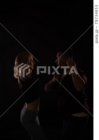 a man and a woman dance together to music in the dark 79734653