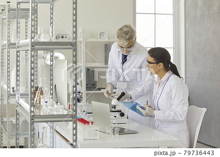 Scientists working in laboratory, taking test samples and doing medical research 79736443