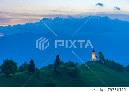 Charming little St. Primus and Felician church in Jamnik, Julian Alps, Slovenia and beautiful sunrise sky colors 79736566