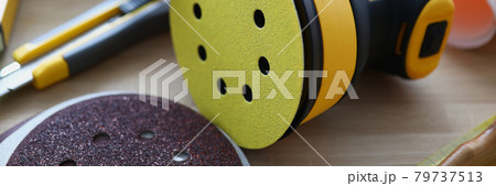Yellow disc sander is on table closeup Yellow disc sander is on table closeup 79737513