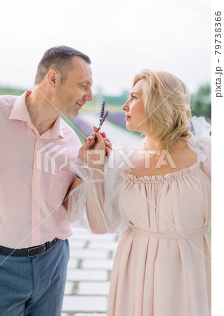 Happy pleasant mature couple in love, standing together outdoors and enjoying the scent of lavender 79738366
