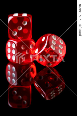 Red casino dice isolated over black reflective background Red casino dice isolated over black reflective background 79738640