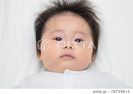 ベッドで寝転んでリラックスする赤ちゃんの女の子 ベッドで寝転んでリラックスする赤ちゃんの女の子 79739613