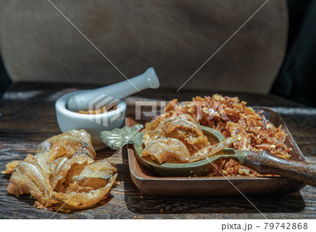 Dried chilli paste with crispy fish thai style or Crispy fish chilli paste in ceramic white cup on wooden table. Dried chilli paste with crispy fish thai style or Crispy fish chilli paste in ceramic white cup on wooden table. 79742868