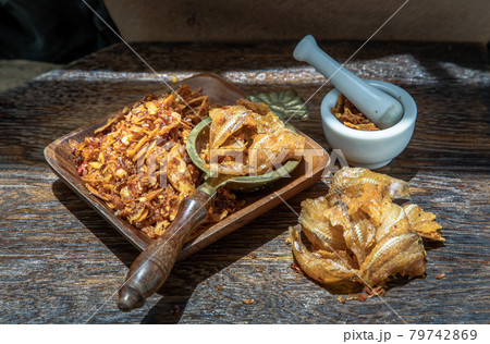 Dried chilli paste with crispy fish thai style or Crispy fish chilli paste in ceramic white cup on wooden table. 79742869