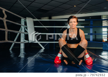 portrait of a female boxer in red gloves in the gym during training portrait of a female boxer in red gloves in the gym during training 79742932