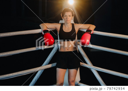portrait of a female boxer in red gloves in the gym during training portrait of a female boxer in red gloves in the gym during training 79742934