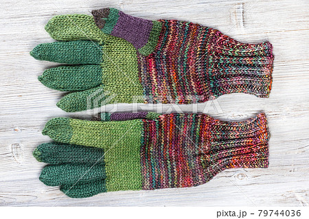 palm side of hand knitted woolen gloves on gray 79744036