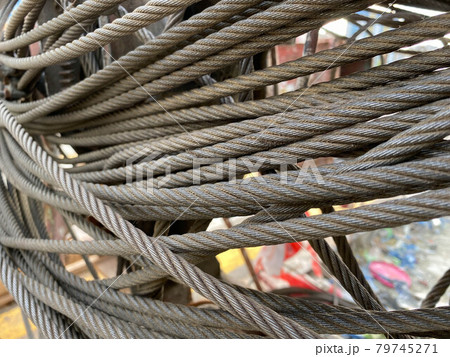 Clean new steel cable, steel wire or steel rope wound on a bobbins standing on a shelf 79745271