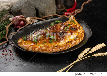Pizza calzone on a black plate Pizza calzone on a black plate 79745946