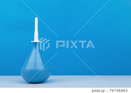 Blue medical enema on white table against blue background with copy space Blue medical enema on white table against blue background with copy space 79746863