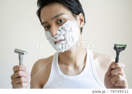 どちらの髭剃りにするか迷う男性 79749511